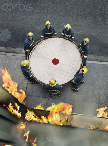 Firefighters holding safety net --- Image by © Anthony Redpath/Corbis